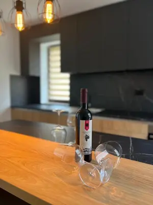 a bottle of wine and glasses on a kitchen counter at Apartment Lux Lucis in Livno