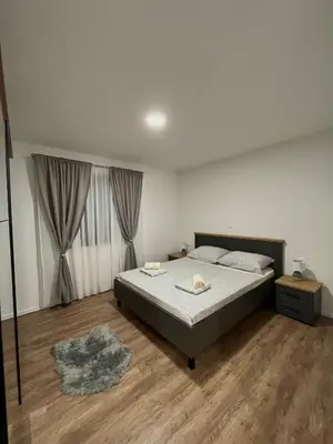 a bedroom with a large bed and a wooden floor at Apartment Lux Lucis in Livno