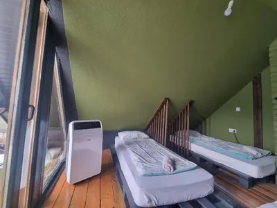 two twin beds in a room with green walls at Jajce lake cottage-Plivsko jezero in Jajce