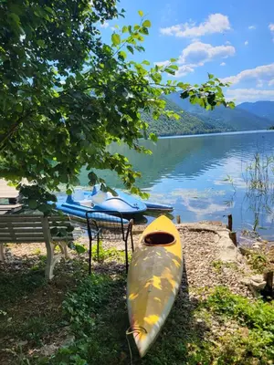 a yellow kayak sitting on the shore of a lake at Jajce lake cottage-Plivsko jezero in Jajce