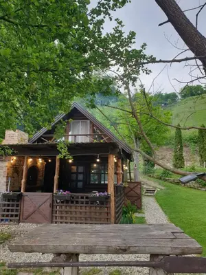 a small house with a porch and a wooden bridge at Jajce lake cottage-Plivsko jezero in Jajce