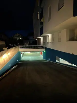 an empty parking lot in front of a building at night at Apartman Vila Bojana in Budžak