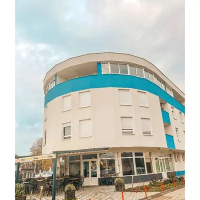 a large white building with blue trim at Apartman Vila Bojana in Budžak