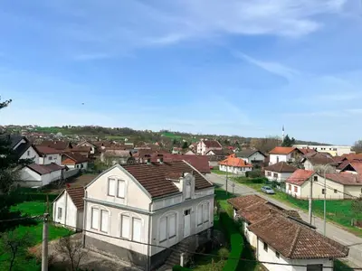 a large white house in a town with houses at Apartman MS in Bosanska Dubica