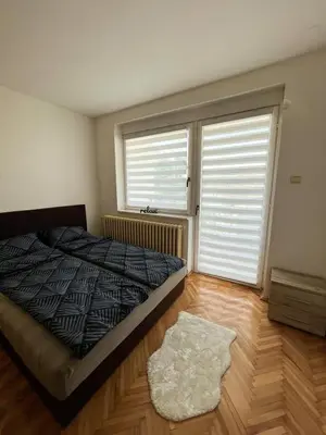 a bedroom with a bed and a large window at Apartman MS in Bosanska Dubica
