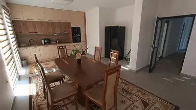 a kitchen with a table and chairs in a room at Grand Apartman in Živinice
