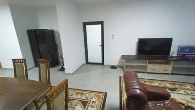 a living room with a dining table and a television at Grand Apartman in Živinice
