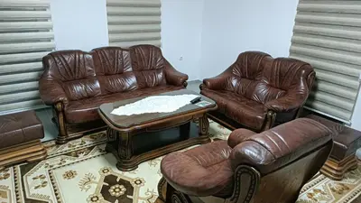 a living room with leather chairs and a table at Grand Apartman in Živinice
