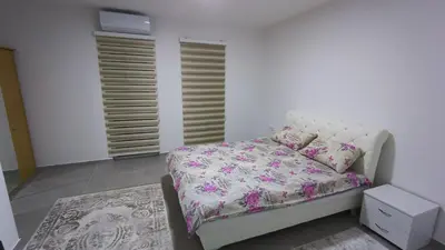 a bedroom with a bed with a pink comforter at Grand Apartman in Živinice