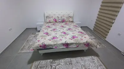 a bedroom with a bed with a floral bedspread at Grand Apartman in Živinice