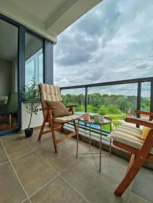 a balcony with a chair and a glass table at Park & Play in Banja Luka