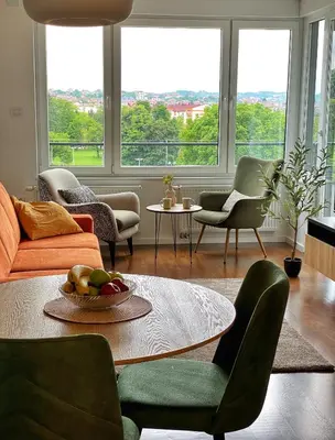a living room with a table and chairs and windows at Park & Play in Banja Luka