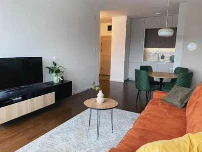 a living room with a orange couch and a television at Park & Play in Banja Luka