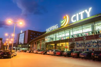 a shopping center with cars parked in a parking lot at Hotel Zenica in Zenica