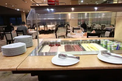 a restaurant with plates of food on a counter at Hotel Zenica in Zenica