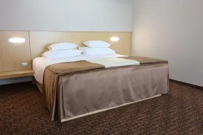 a bedroom with a bed with white pillows at Hotel Zenica in Zenica
