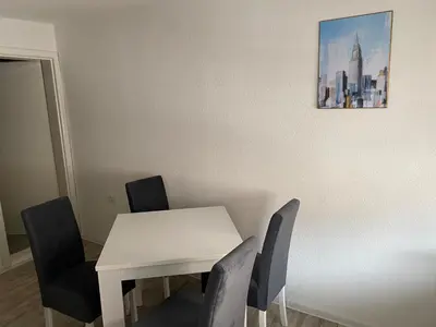 a white table and chairs with a picture on the wall at Apartman Downtown in Bosanski Novi