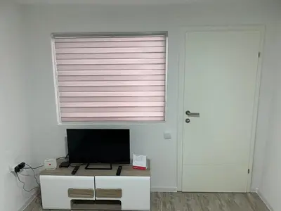 a room with a window with a monitor on a white cabinet at Apartman Downtown in Bosanski Novi