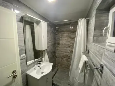 a bathroom with a toilet and a sink and a shower at Apartman Downtown in Bosanski Novi
