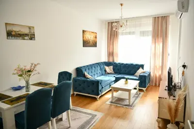 a living room with a blue couch and a table at Apartman Panorama Banja Luka in Banja Luka