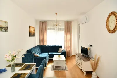 a living room with a blue couch and a table at Apartman Panorama Banja Luka in Banja Luka