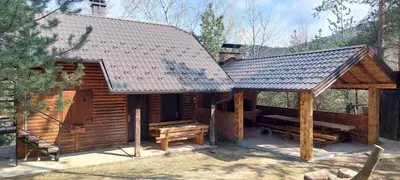 a log cabin with a porch and a bench at Naša Maša Doboj - farma jelena Nasa Masa Doboj in Doboj