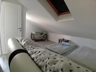 a bedroom with a bed and a room with a car at Stan Nova Varos Banjaluka in Banja Luka