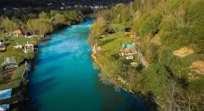 an aerial view of a river with blue water at Hacienda Burzić in Kulen Vakuf