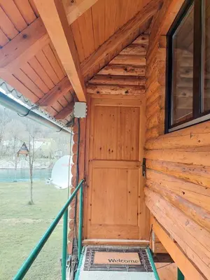 a wooden door on a cabin with a porch at Hacienda Burzić in Kulen Vakuf