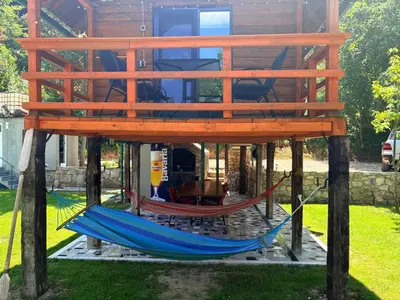 a house with two hammocks in a yard at Hacienda Burzić in Kulen Vakuf
