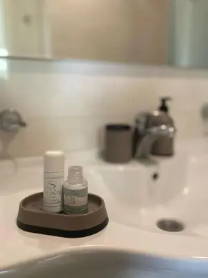 a bathroom sink with a bottle of medicine on it at Skylight studio Banja Luka in Banja Luka