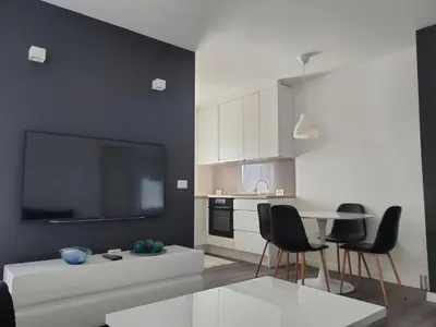 a living room with a table and chairs and a tv at Apartment Maria in Tomislavgrad