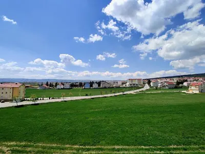 a field of green grass with a city in the background at Apartment Maria in Tomislavgrad