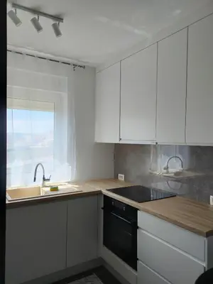 a kitchen with white cabinets and a sink and a window at Apartment Maria in Tomislavgrad