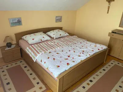 a bed in a small room with a bedspread and pillows at Apartman Zeko in Kupres