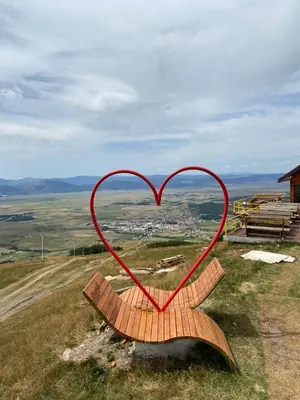a heart shaped wooden bench on top of a hill at Apartman Zeko in Kupres