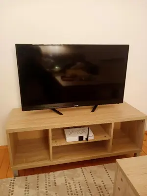 a flat screen tv sitting on a wooden entertainment center at Family House بيت عائلي بجميع مواصفات الراحة in Travnik