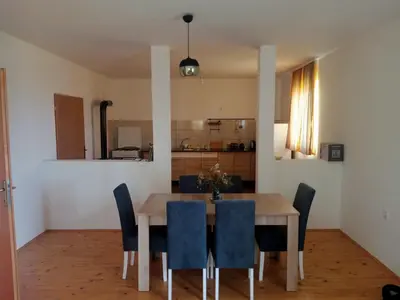 a dining room with a wooden table and blue chairs at Family House بيت عائلي بجميع مواصفات الراحة in Travnik