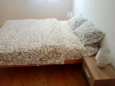 a bed with a white comforter and two pillows at Family House بيت عائلي بجميع مواصفات الراحة in Travnik