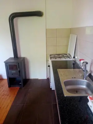 a small kitchen with a stove and a sink at Family House بيت عائلي بجميع مواصفات الراحة in Travnik