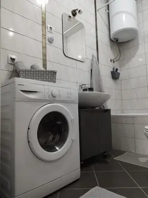 a washing machine in a bathroom with a sink at Apartman Green City with garage in Banja Luka