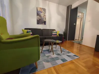 a living room with a couch and a table at Apartman Green City with garage in Banja Luka