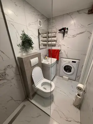 a bathroom with a toilet and a washing machine at Apartman DIJANA BANJA LUKA in Banja Luka