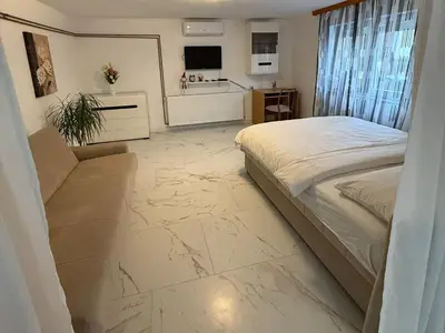 a bedroom with a large bed and a tiled floor at Apartman DIJANA BANJA LUKA in Banja Luka