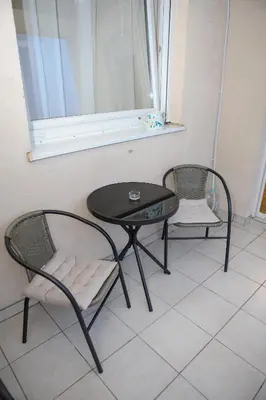 two chairs and a table in a room with a window at Iva Lux stan na dan in Banja Luka