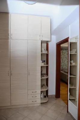 a dressing room with white cabinets and a mirror at Iva Lux stan na dan in Banja Luka