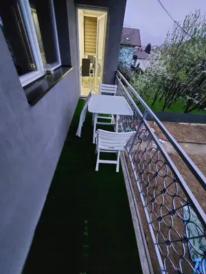 a patio with a table and chairs on a balcony at L’appartement de la Pyramide du Soleil in Visoko