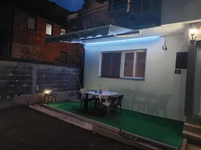 a table and chairs on a patio at night at L’appartement de la Pyramide du Soleil in Visoko