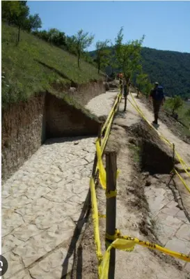a yellow rope fence on a dirt road at L’appartement de la Pyramide du Soleil in Visoko