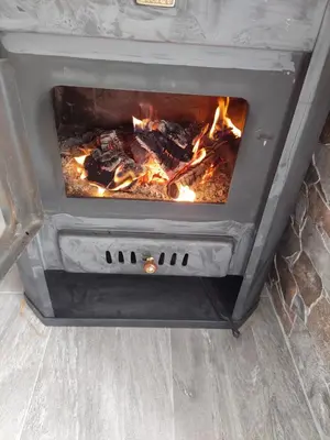 a stove with a fire in a room at L’appartement de la Pyramide du Soleil in Visoko